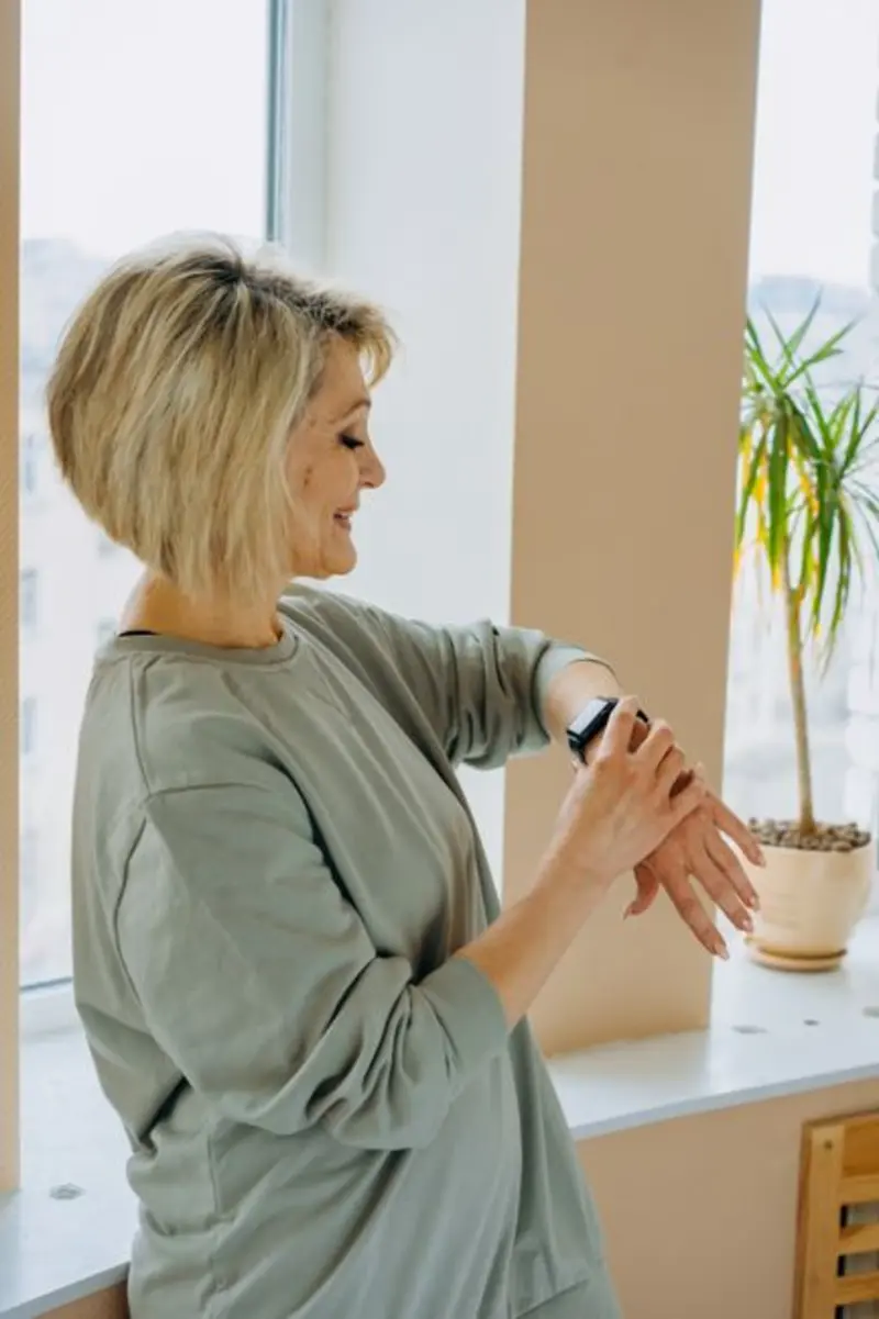 Frau schaut im Studio zwischen zwei Sätzen auf ihre Apple Watch